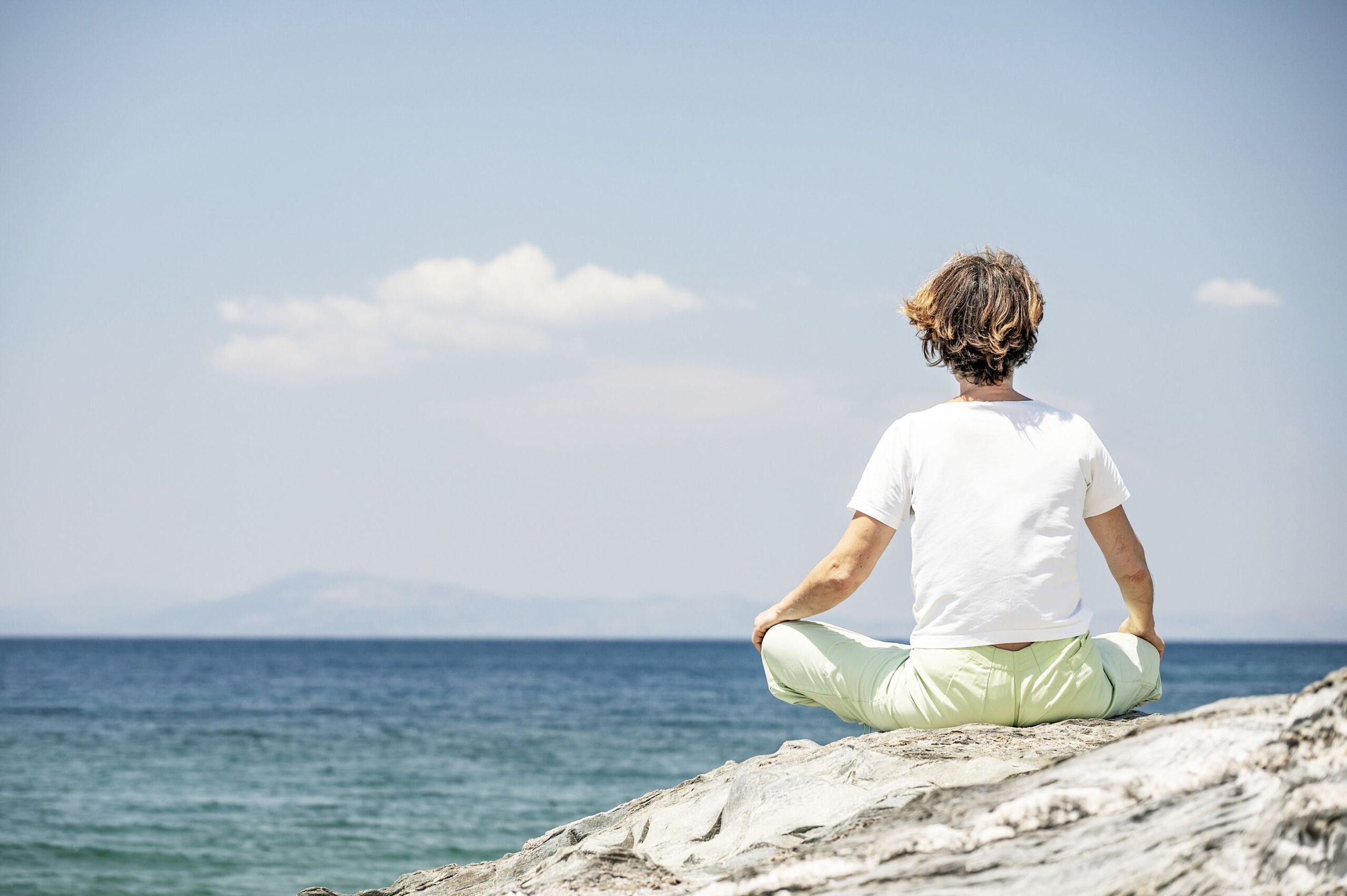 iliohoos095 Frau meditiert am Meer, Yoga Entspannung, Achtsamkeit